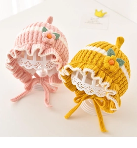 Adorable knit baby hats in pink and yellow with cute floral accents and lace-up straps