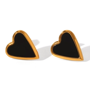 Detailed view of heart-shaped gold studs with black acrylic inlay and polished finish