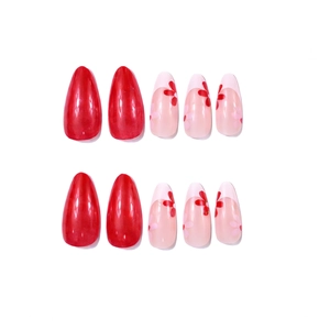 Detail of 10 almond-shaped press-on nails featuring solid red and pink floral designs
