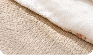 Detail van wit sherpa fleece en beige geweven stof op de deken voor huisdieren