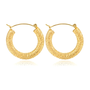 Macro shot of gold-plated stainless steel C-shaped earrings with hammered texture finish