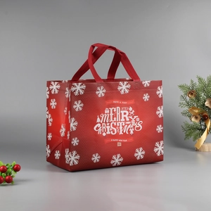 Close-up of a festive red Christmas gift bag with white snowflakes and holiday greetings