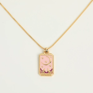 Macro detail of gold Tarot The Moon pendant with pink and purple enamel landscape art