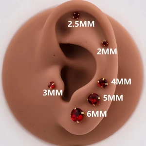 Detail showing red cubic zirconia stud earrings in various sizes from 2mm to 6mm gold pins