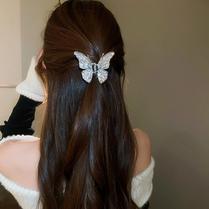 Detail of silver butterfly hair claw with sparkling zircons worn on long dark hair