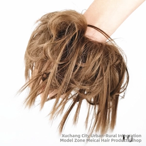 Detailed close-up of light brown messy bun hairpiece with a voluminous textured finish