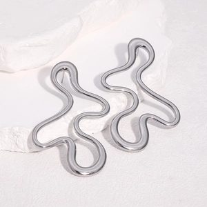 Minimalist silver wavy stud earrings with irregular design on white textured stone