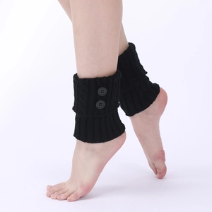 Detail of black cable knit leg warmers with two functional buttons on model legs
