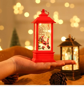 Close-up of a glowing red LED Christmas lantern with Santa Claus illustration
