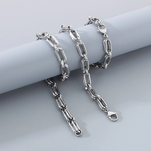 Detailed view of silver paperclip and O-link chain necklace with inset crystals