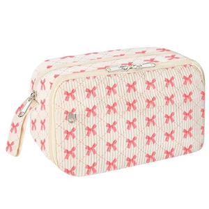 Detail of quilted pencil case with pink bow patterns and dual zipper compartments