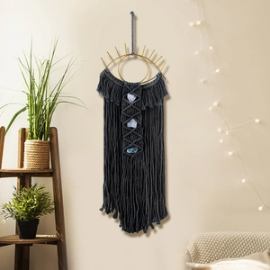 Detail of handmade woven tapestry with metal evil eye frame and natural crystal stones