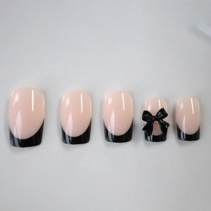Pink and black French press-on nails with 3D bow design on minimalist white background