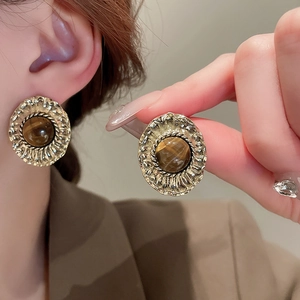 Vintage gold oval tiger eye earrings with textured metal frame and Maillard style