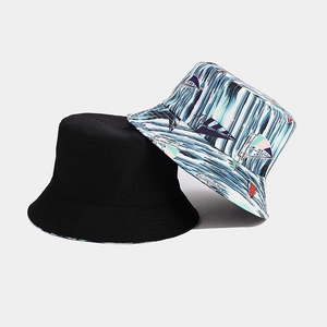 Detail of reversible bucket hat showing classic black fabric and nautical sailboat print