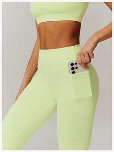 Detail shot of functional side pocket on neon green high waist yoga pants for smartphones