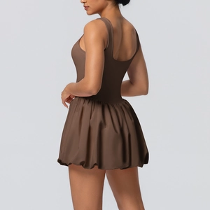 Detail of a brown tennis romper dress featuring a stylish bubble hem and open back design