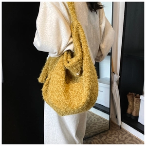 Detailed view of yellow plush tote bag showing soft texture and large shoulder strap