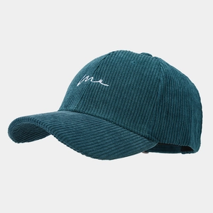 Détail d'une casquette en velours côtelé bleu foncé avec broderie cursive blanche 'me'