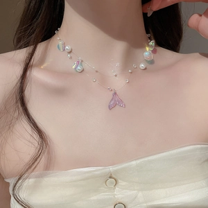 Detailed macro view of the double-layered shell and fishtail pearl pendant necklace