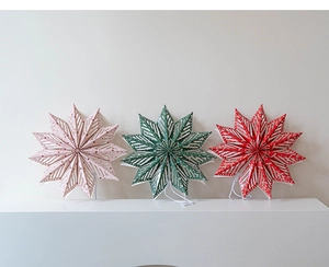 Three 3D paper star lanterns in pink, green, and red with white geometric patterns