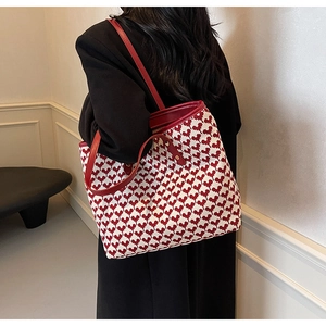 Detail of red heart patterns on canvas tote bag with premium leather handle
