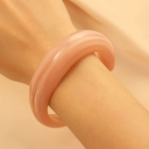 Detail eines rosa Harz-Armreifs mit weicher Marmorierung und breitem, rundem Band