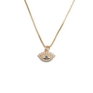 Dettaglio macro della collana con ciondolo occhio del male dorato e cristallo blu incastonato