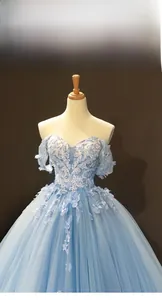 Detail of light blue off-shoulder gown featuring intricate 3D lace floral appliques