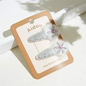 Detail of silver glitter Christmas hair clips with white pompom and snowflake rhinestone