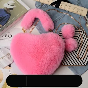 Pink heart-shaped faux fur crossbody bag with gold chain and plush charms on flat lay