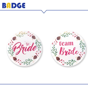 Detailed view of floral Bride and Team Bride tinplate badges for bridal shower