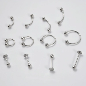 Detailed set of silver stainless steel curved barbells, horseshoe rings, and labret studs