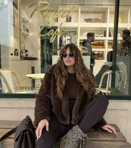 Street style shot of a woman in a short brown faux fur coat and platform snow boots