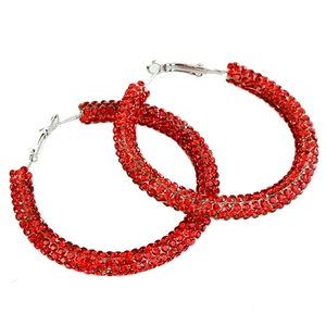 Détail de créoles de Noël avec strass rouges étincelants et tiges en argent brillant