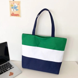 Close-up of three-color patchwork canvas tote bag with durable navy blue top handles