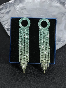Close-up of long mint green tassel earrings with high-density rhinestones and blue gift box