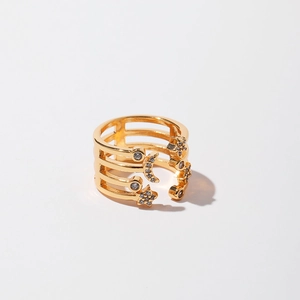 Macro detail of gold-plated open ring with zircon-studded star and moon charms