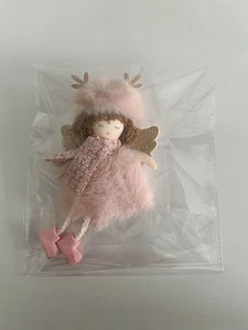 Detailed view of plush pink Christmas angel ornament with golden wings in packaging