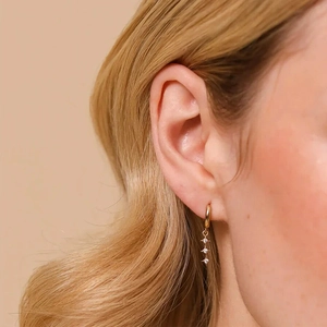 Elegant gold drop earrings with three dangling stars and sparkling zircon inlay