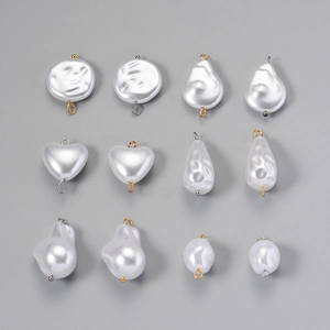 Flat lay of baroque faux pearl charms in heart and drop shapes with metal connectors