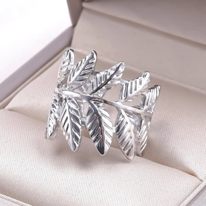 Macro detail of silver stainless steel wide open ring featuring a leaf pattern