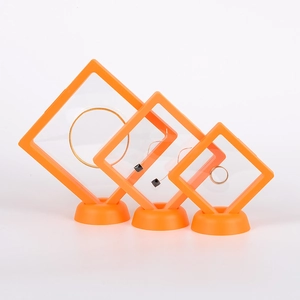 Three orange PE film floating display boxes for jewelry with circular stands in three sizes