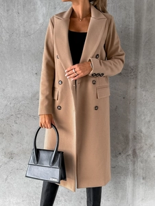 Detail of camel wool coat showing double-breasted design and twill fabric texture