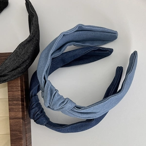 Close-up of denim knotted headbands in black, light blue, and dark blue denim fabric