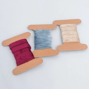 Detail of burgundy, blue and beige velvet ribbons on cardboard spools for DIY decor