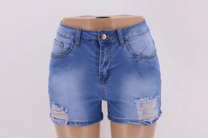 Close-up of distressed denim shorts in light blue with frayed hems and whisker detailing