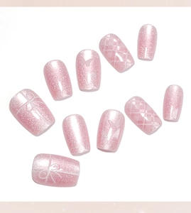 Detail of pink cat-eye press-on nails with 3D butterflies and lattice patterns