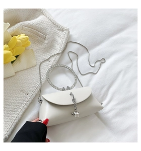 Macro shot of white irregular jelly handbag with rhinestone ring handle and silver chain