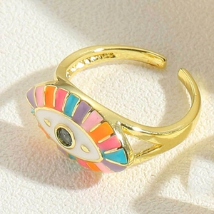 Macro view of gold devil eye ring with colorful enamel inlay on textured beige fabric